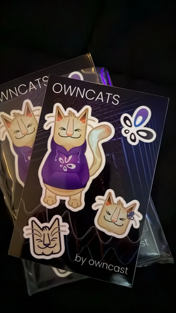 A sheet of stickers. One with a full body of a cat wearing a purple hoodie with the Owncast logo, another with the head of Owncat wearing a Owncast-logo shaped bow in their hair (fur?), and another stylized version of the Owncat head. There also shows the Owncast logo and the text "OWNCATS BY OWNCAST".