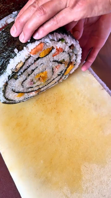 Umewaka Sushi in Japan makes largest Sushi Roll prepared at this unique establishment is called the "Generous Roll" and contains 24 tasty ingredients, including a variety of fish and seafood, vegetables, rice, all laid out on a 2-meter-long piece of dried seaweed.