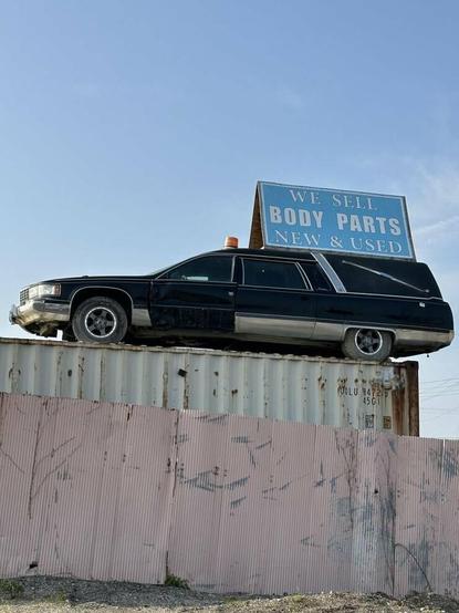 Hearse with "We sell body parts sign" on top
