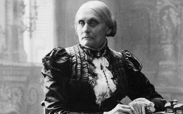 Photo of Susan B Anthony. She is a white woman with white hair, dressed in high Victorian clothing.