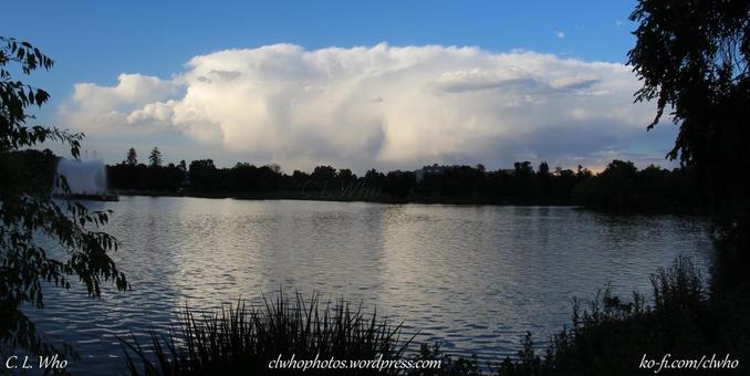 Cumulonimbus clouds in the distance with a lake.