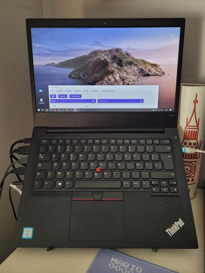 Un Lenovo ThinkPad E480 posé sur 1 support pour ordinateur qui est invisible sur la photo. Il est comme neuf.