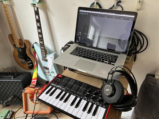 Snapshot of my little, messy music corner, with my laptop, MIDI input device and some guitars and amps in the background