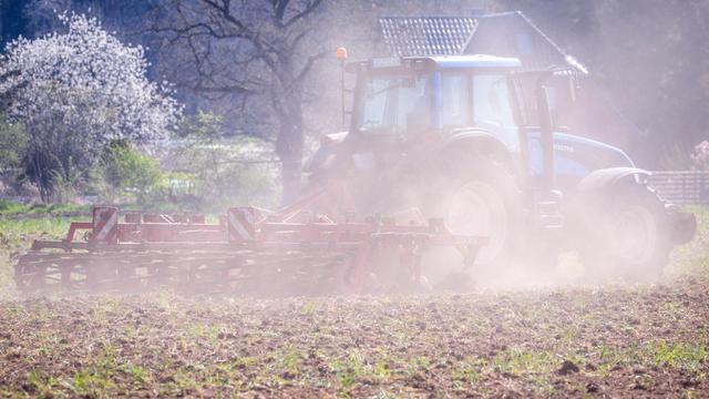 Ein Traktor zieht eine Egge über ein Feld und wirbelt eine Staubwolke auf. Fehlender Regen und kräftige Winde die für eine Austrocknung des Bodens sorgen bereiten den Landwirten in Norddeutschland zunehmend Sorgen.