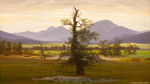 Gemlälde von Caspar David Friedrich: Ein Baum steht auf einer Wiese vor Bergen 