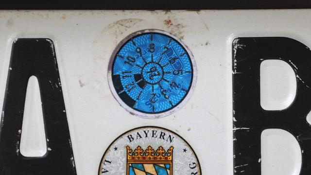 Eine TÜV- Plakette auf einem PKW-Nummerschild