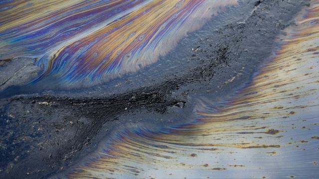 Streaks of iridescent materials suggesting the presence of organic chemicals.