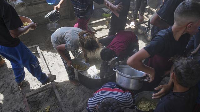 Palestinian children scrape a pot for leftover food after all meals were distributed at a community kitchen in Khan Younis, southern Gaza Strip, on Friday, May 9, 2025. (AP Photo/Abdel Kareem Hana) Palestinian children scrape a pot for leftover food after all meals were distributed at a community kitchen in Khan Younis, southern Gaza Strip, on Friday, May 9, 2025. (AP Photo/Abdel Kareem Hana)