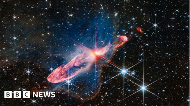 A red star in the process of  forming against a field of stars.