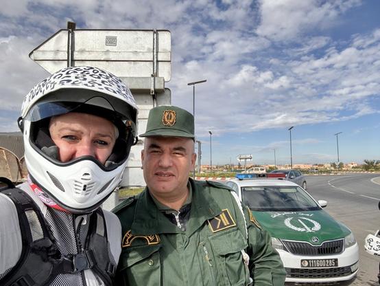A selfie of myself, wearing a motorbike helmet, and an Algerian policeman