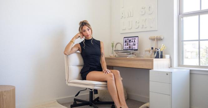 Alyssa Sheil sitting at her desk. All of her decor is white, cream, and beige. Alyssa Sheil sitting at her desk. All of her decor is white, cream, and beige.