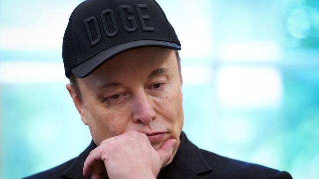 Elon Musk, bearing a black eye, listens as U.S. President Donald Trump speaks to reporters in the Oval Office of the White House.