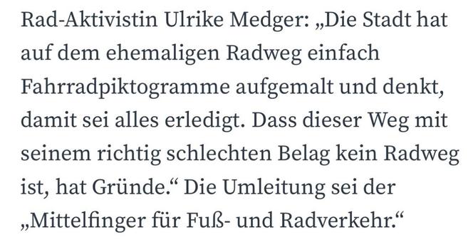 Das Bild enthält ein Zitat der Fahrradaktivistin Ulrike Medger, das über die Unzulänglichkeit von mit Piktogrammen markierten Radwegen auf einem schlecht oberflächen ehemaligen Radweg spricht. Es kritisiert den Ansatz der Stadt und erwähnt, dass der Umweg ein "Mittelfinger" ist
