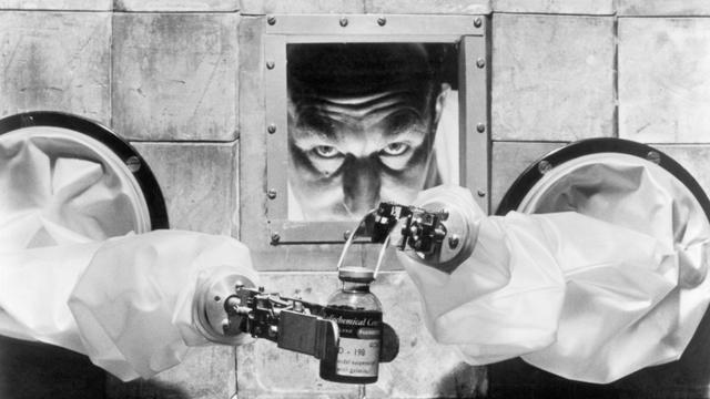 A 1956 scientist carefully bottles isotopes with robotic arms from behind a protective wall at the Radiochemical Centre, one of the largest pharmaceutical factories in the world.