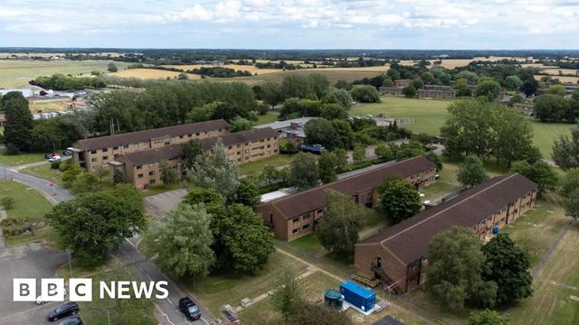 An aerial view of RAF Wethersfield showing four rows of long, red-brick buildings with fields in the background