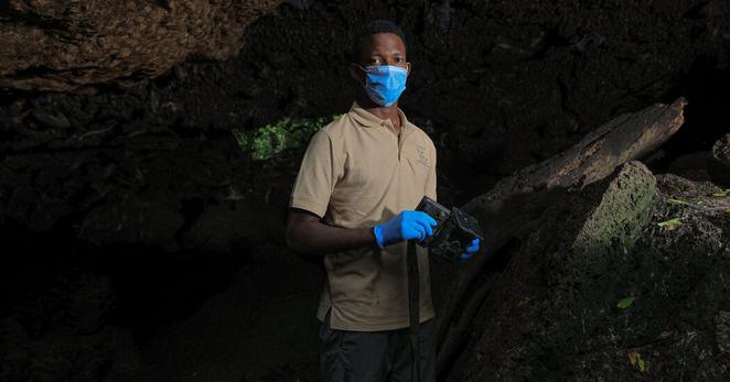 Bosco Atukwatse, a wildlife biologist working with the Kyambura Lion Project, holding one of the trail cameras he worked with. “It was amazing how many animals come to eat bats at that specific spot,” he said.