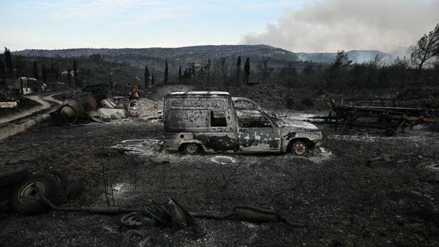 A burnt-out vehicle in an area devastated by a wildfire near Fontjoncouse, southwestern France, on 6 August, 2025. | AFP - LIONEL BONAVENTURE