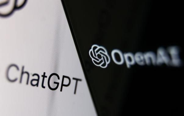 OpenAI logo displayed on a phone screen and ChatGPT website displayed on a laptop screen.