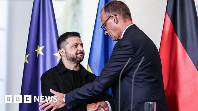 German Chancellor Friedrich Merz, right, shakes hands with Ukrainian President Volodymyr Zelensky, in front of German, Ukrainian and EU flags, after a press conference
