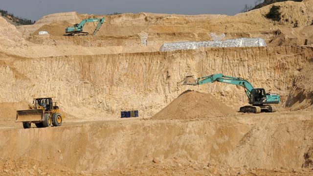 Workers use machinery to dig at a rare earth mine in Ganxian county in central China's Jiangxi province on Dec. 30, 2010. (Chinatopix via AP, File)