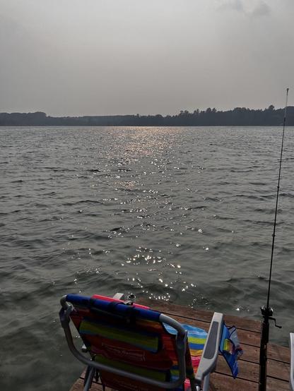 Lake view with dock chair and fishing pole 