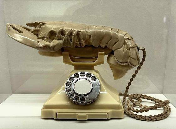 An old-fashioned dial telephone with a plastic lobster on the handset.