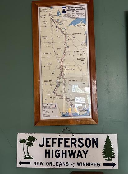 Road map showing the central part of the US and a small part of Manitoba. It's labeled Jefferson Highway (Pine to Palm Highway). The legend shows 1916 and 1929 routes.
Also a sign, JEFFERSON HIGHWAY, NEW ORLEANS - WINNIPEG, with representations of palm and pine trees.
