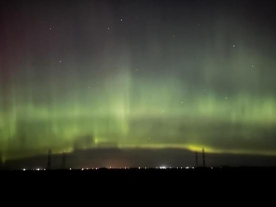 Mostly horizontal greenish glow in the night sky