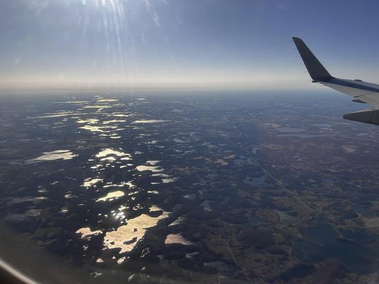 The sun glints off some lake surfaces (seemingly partially frozen) while others show less contrast.