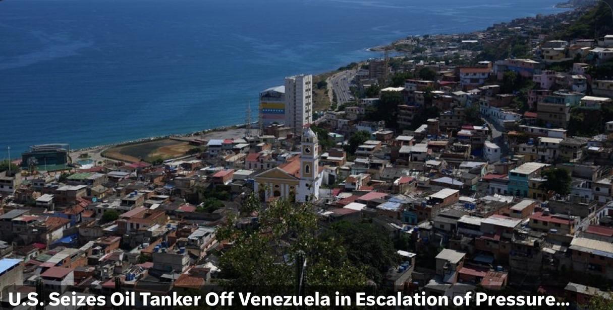 A coastal view of a densely populated community with varying building colors and styles, bordered by a blue ocean, Venezuela. The foreground features a church with a white facade and yellow details, while the background includes a winding road and more urban development along the shoreline.
