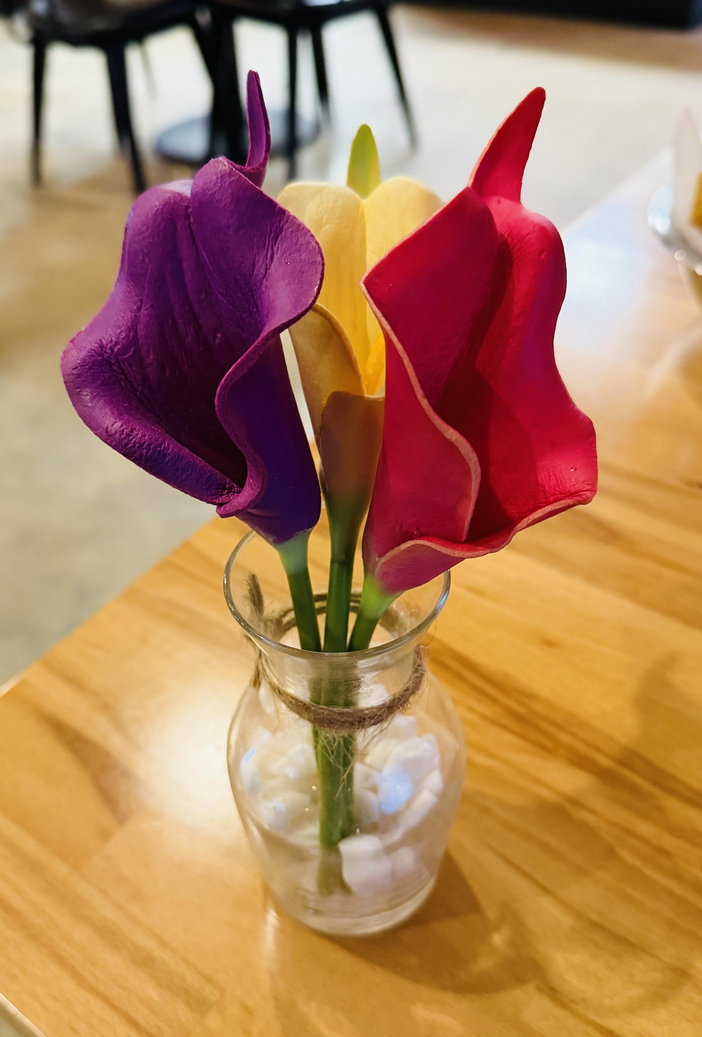 Bright paper flowers, calla lilies, on a restaurant table
