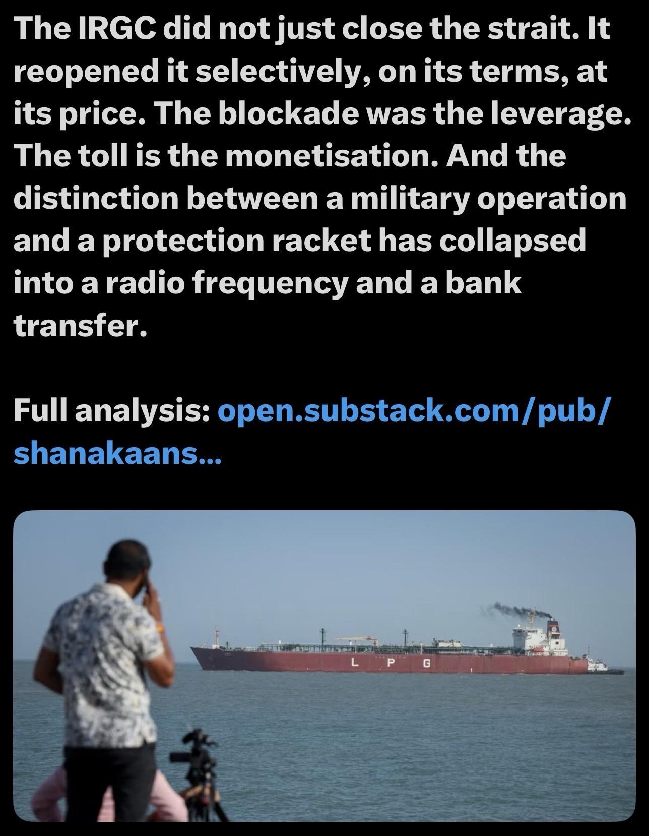 An individual stands by the water, talking on a phone, while a large LPG tanker is visible in the background. The scene depicts a coastal environment.