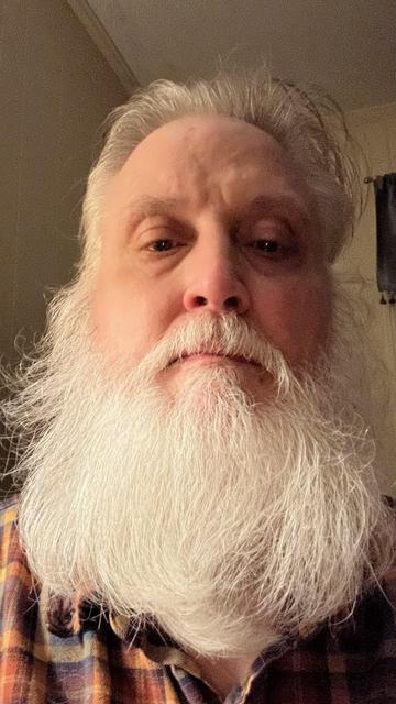 Old white guy with a white beard that shows no signs of recent trimming.