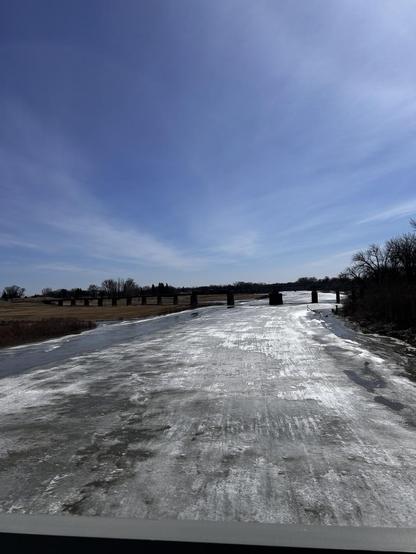 Looking southward from the DeMers bridge at Grand Forks, North Dakota / East Grand Forks, Minnesota, onto the mostly frozen Red River of the North. The linear features are snowmobile tracks.