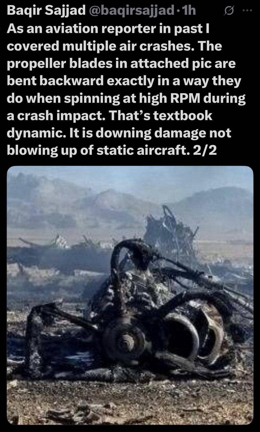 A close-up image of a severely damaged aircraft wreckage, highlighting bent propeller blades and various burned components, with a barren landscape in the background, text, text: prop blades bent backwards indicate a crash impact…