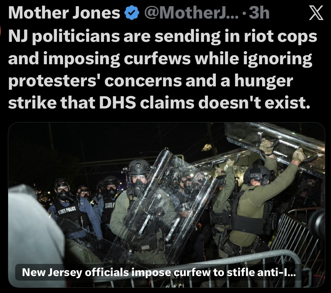 The image shows a line of police officers in riot gear, equipped with shields, amidst a nighttime protest scene. The background is dark, indicating a tense atmosphere. An overlay of text discusses the actions of New Jersey politicians regarding curfews and the response…
