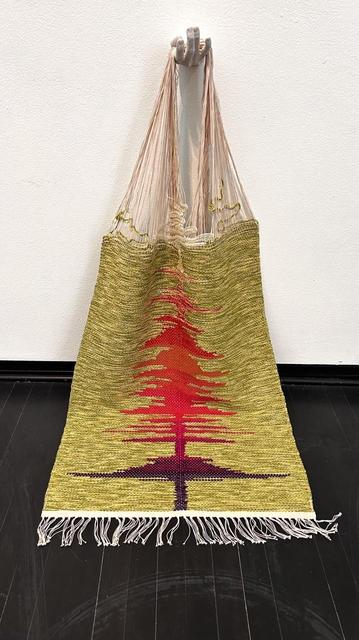 A fringe rug, unfinished, with long strands of warp hanging from a sculptured hand attached to the wall. 
The background is yellow-greenish; along the axis is a purple to reddish pattern resembling an audio spectrum.

Not shown: headphones in which one can hear the artist speaking the text