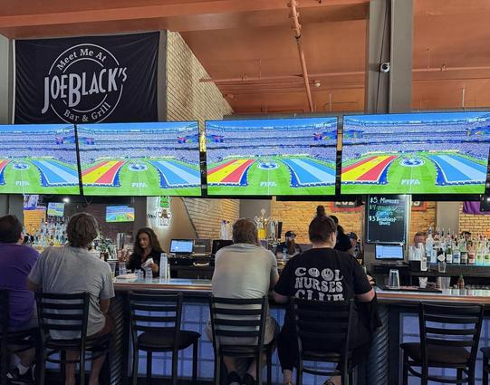 Inside of a pub with TV screens showing pregame ceremonies of World Cup 