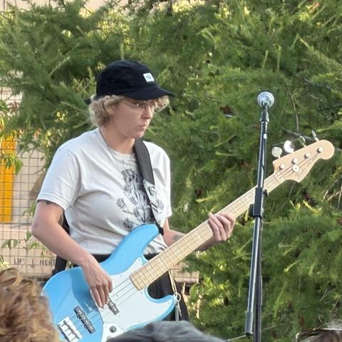 A person playing an electric bass guitar 
